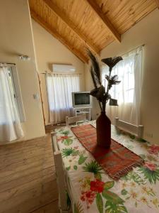 a room with a table with a vase of flowers on it at Cabañas Aires de Campo I in Victoria