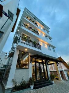 a white building with a balcony with plants at Saffron Boutique Hotel in Da Lat