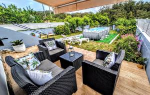 a patio with wicker furniture and a swimming pool at Casa Carmen e do Hilario in Ponte Do Porto