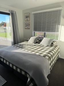 a large bed in a bedroom with a window at Denbigh Homestay in Midhirst