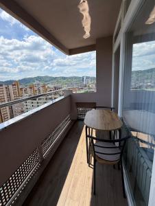 a balcony with a table and chairs and a view at Bella Mela 2 in Tuzla