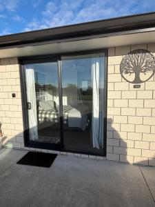 a room with sliding glass doors with a bed at Denbigh Homestay in Midhirst