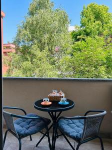 a table with two chairs and a basket on a balcony at Nuara Urban Loft in Novara