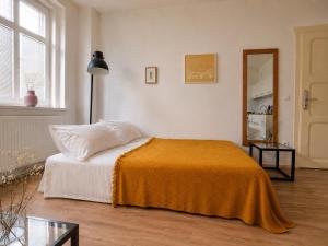 a bedroom with a bed with an orange blanket at Villa Medica in Kraslice