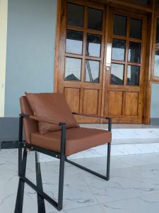 a brown chair sitting in front of a door at Nyumbani Executive Lodge in Ilala +2 photos