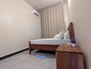 a bedroom with a bed and a wooden table at Nyumbani Executive Lodge in Ilala