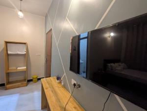 a living room with a large television on a wall at Nyumbani Executive Lodge in Ilala