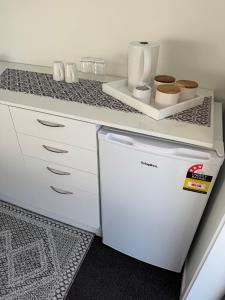 a kitchen with a white refrigerator and a counter at Denbigh Homestay in Midhirst +5 photos