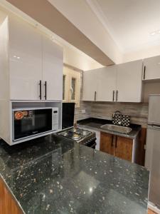 a kitchen with white cabinets and a black counter top at LuXURY STUDIOS MATROUH 3 in Marsa Matruh +22 photos