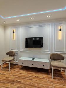a living room with two chairs and a flat screen tv at LuXURY STUDIOS MATROUH 3 in Marsa Matruh