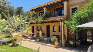 a building with a patio with tables and chairs at Casa Naya Ibiza in Sant Llorenç de Balafia +18 photos