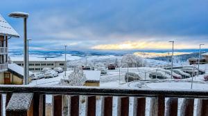 a snowy view of a parking lot with cars parked at Le Nid du Sancy - Les Matins du Sancy - Super-Besse in Super Besse