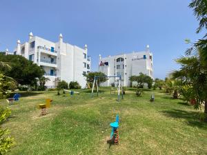a playground in a park in front of a building at Elegant Beach View Apartment in Kabila Vista in Marina Smir