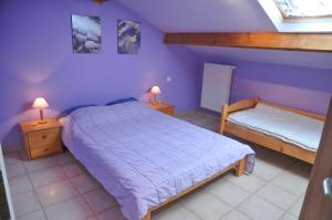 GrandhanにあるCote Jardinの紫の壁のベッドルーム1室、ベッド1台、ランプ2つが備わります。