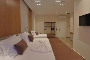 a hotel room with two beds and a flat screen tv at Hotel Landi in Ksamil