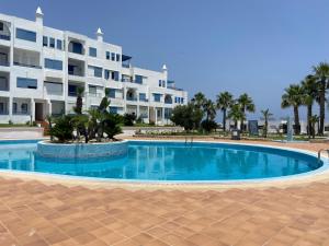 a swimming pool in front of a large apartment building at Elegant Beach View Apartment in Kabila Vista in Marina Smir