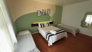 a bedroom with two beds in a room at Pousada Puerta Del Sol Rio das Ostras in Rio das Ostras +183 photos