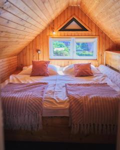 a large bed in a wooden room with two pillows at vila Barbara - Vysoké Tatry in Stará Lesná +73 photos