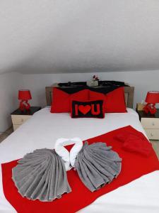 a bed with red and white blankets and a wvu pillow at Park Apartment in Kočani