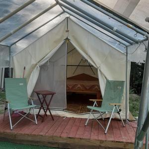 a tent with two chairs and a table in it at Riverfront Ritz campsite in Lake Luzerne