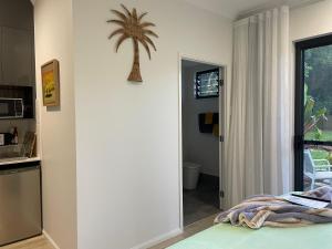 a bedroom with a palm tree on the wall at Eden on Beach in Palm Cove