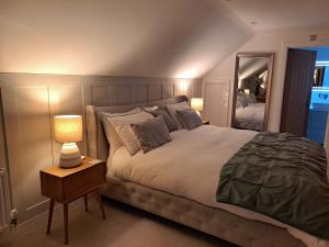 a bedroom with a large bed and a lamp on a night stand at Nanny lane loft in Church Fenton