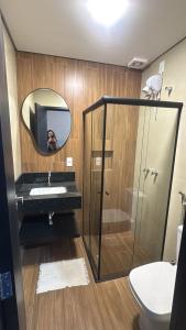 a person taking a picture of a bathroom with a mirror at Carrijo Hotel in Marília +73 photos