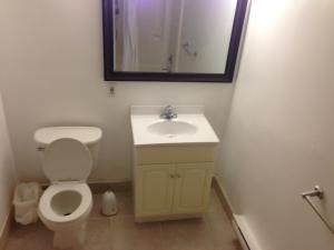 a bathroom with a toilet and a sink and a mirror at Cloud 9 Inn - Beach Hotel in Seaside Heights