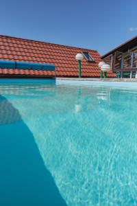 a large swimming pool with a red roof at vila Barbara - Vysoké Tatry in Stará Lesná