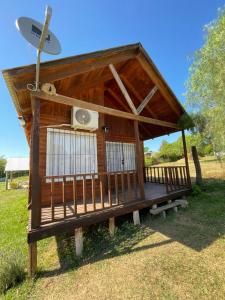 a small wooden house with a satellite at Cabañas Aires de Campo II in Victoria