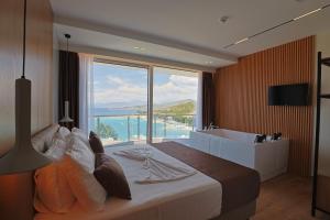 a bedroom with a large bed with a large window at Hotel Landi in Ksamil +156 photos