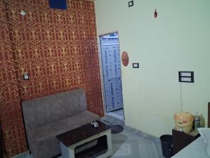 a living room with a couch and a red wall at Hotal Relax in Saharsa