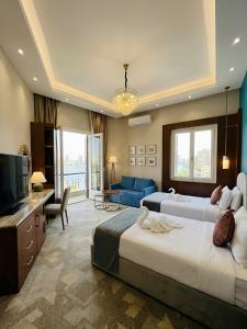 a hotel room with two beds and a television at Grand City Hotel River View in Cairo