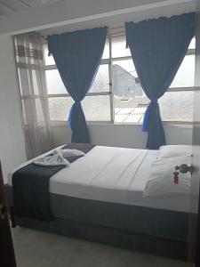 a bedroom with a bed with blue drapes at Alojamiento donde Nur in Filandia