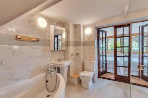 a bathroom with a tub and a sink and a toilet at Horseshoe Pass Holiday Lets in Llangollen