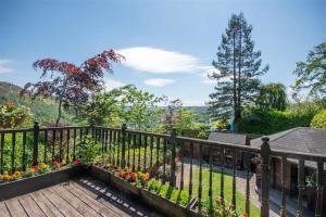 a balcony with a wooden fence and flowers at Horseshoe Pass Holiday Lets in Llangollen