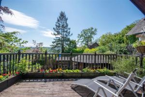 a patio with chairs and flowers on a fence at Horseshoe Pass Holiday Lets in Llangollen