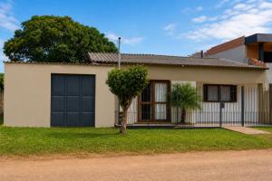 a house with a black garage door at Casa completa em Bagé ideal para familias ate 6 pessoas WiFi e excelente localização in Bagé