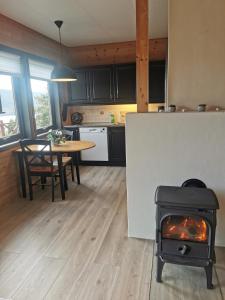 a kitchen and dining room with a stove in a kitchen at Cabin in Kvinnherad in Ølfernes