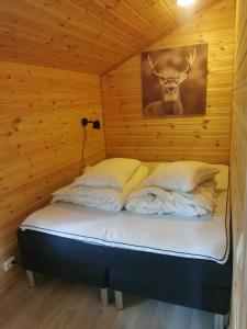 a bed in a room with a deer head on the wall at Cabin in Kvinnherad in Ølfernes