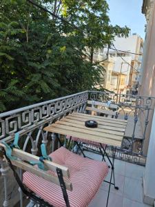 a wooden table and chairs on a balcony at Homeric poems Suites in Chios