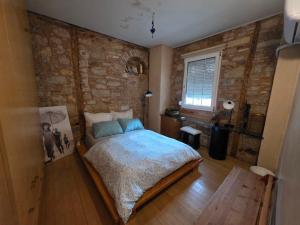 a bedroom with a bed and a stone wall at Homeric poems Suites in Chios +67 photos