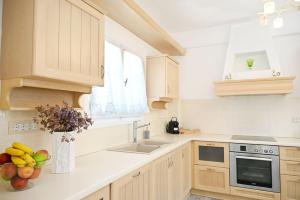 a kitchen with white cabinets and a vase of fruit on the counter at Utopia Kythnos Althea in Kithnos