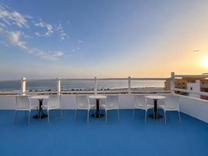 a balcony with tables and chairs overlooking the ocean at Coast anza house in Agadir