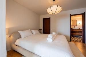 a bedroom with a large white bed with a light at Horizon living Madeira in Caniço +41 photos