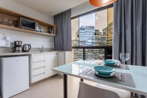 a kitchen with a dining table and a window at Flat Central Arena Policia Federal in Brasília