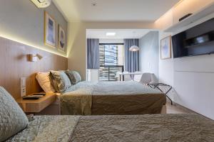 a hotel room with two beds and a window at Flat Central Arena Policia Federal in Brasília