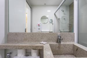 a bathroom with a sink and a mirror at Flat Central Arena Policia Federal in Brasília +17 photos