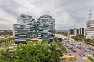 two tall buildings in a city with a parking lot at Flat Central Arena Policia Federal in Brasília