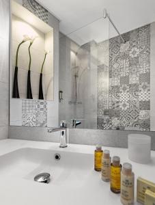 a white bathroom with a sink and a mirror at Hotel Villa Victoria in Nice